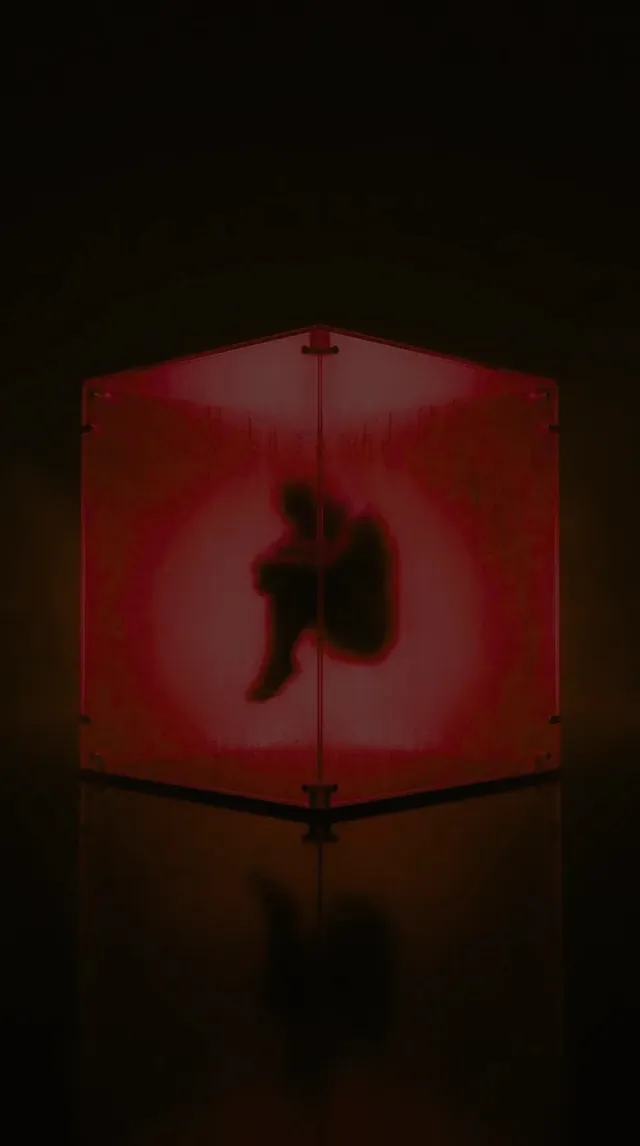 A curled figure inside a glowing red glass cube